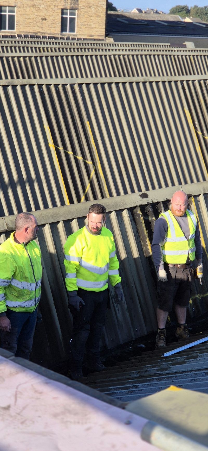 Three of the install team in hi-vis on the warehouse roof